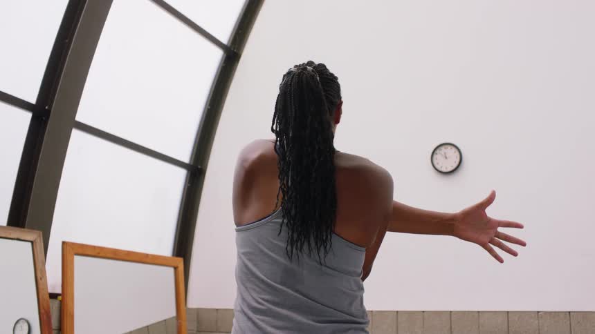 Woman stretching her arm indoors