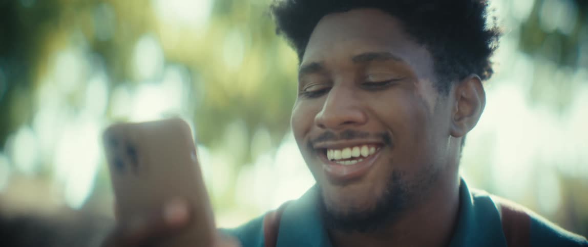 Man smiling while looking at his phone