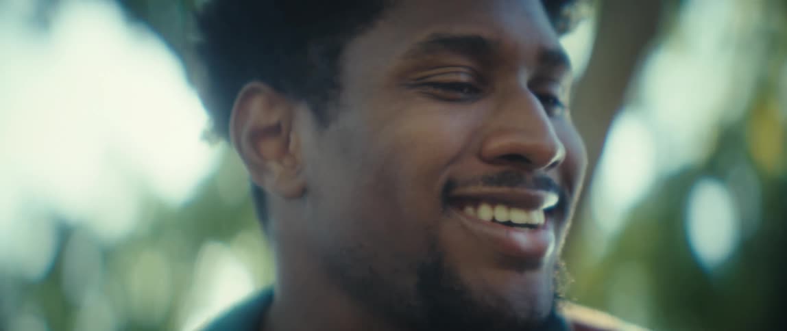 Man smiling while talking outdoors