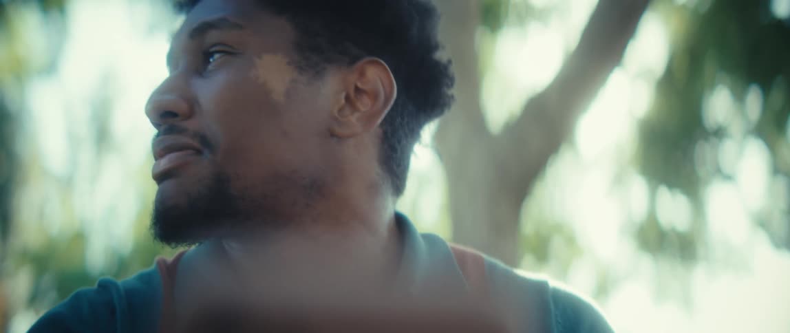 The man looks around while talking on his phone