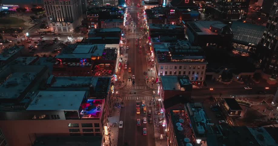Aerial view of a busy city street with traffic and lit buildings at night