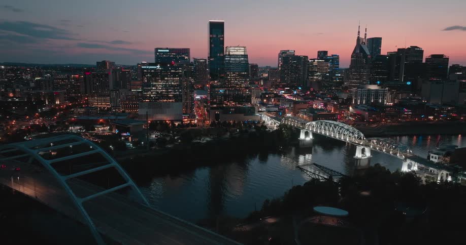 A city skyline at night illuminated by building lights with a series of connecting bridges where cars pass by