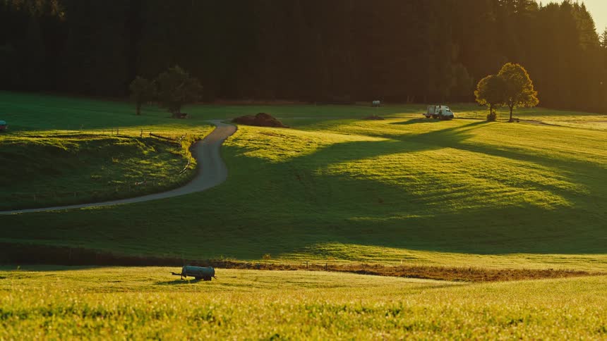 The van drives up the hill and past the forest