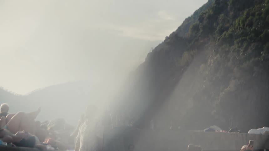 Tourists walk near the green mountain