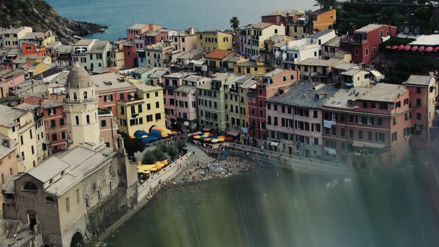 Aerial view of a coastal village with colorful houses surrounding a small bay