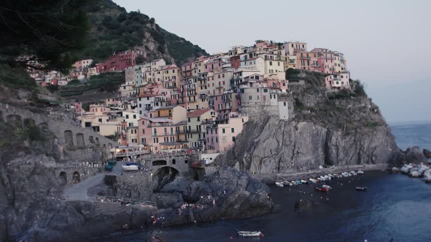 Boats are docked all around the shore of the village on the mountain