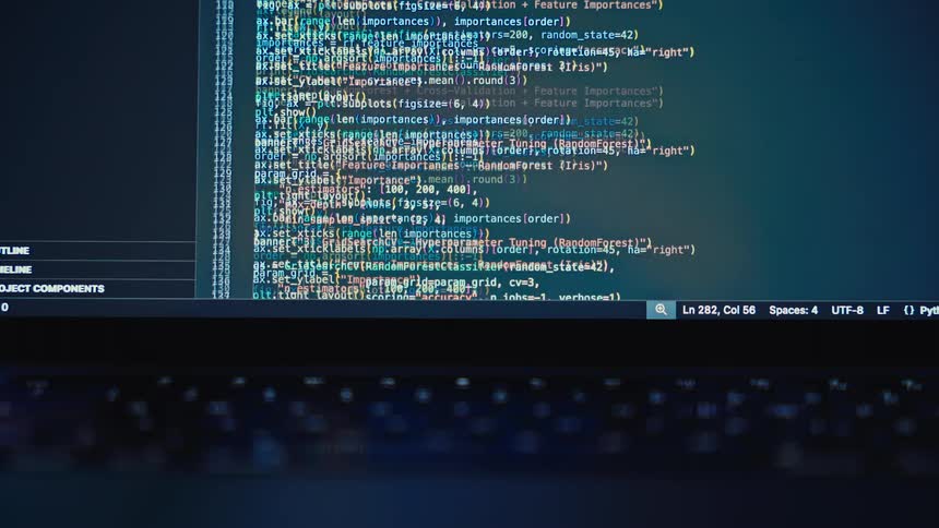 A programming code is displayed on a laptop screen