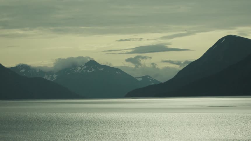 Mountains on a coastal area next to the sea in cloudy weather outdoors