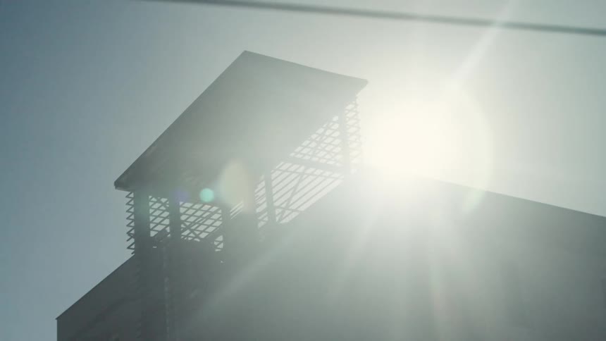 Modern structure with solar panels bathed in intense sunlight on a clear day