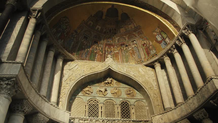 Gilded mosaic and carved marble columns of st marks basilica glow under warm slanting afternoon light