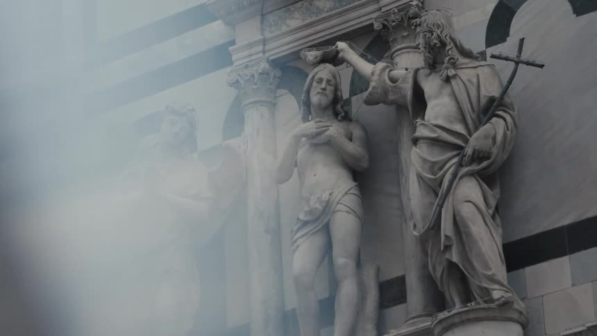 Religious sculptures outdoors on a building pillar in daytime