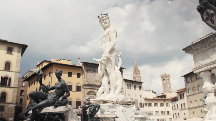 The fountain of neptune in florences piazza della signoria surrounded by statues of men and women at midday