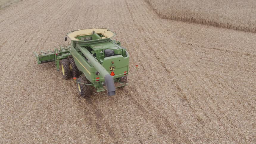 Green tractor in motion on a field outdoors during day time