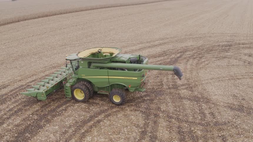 A combine harvester is running through a crop field