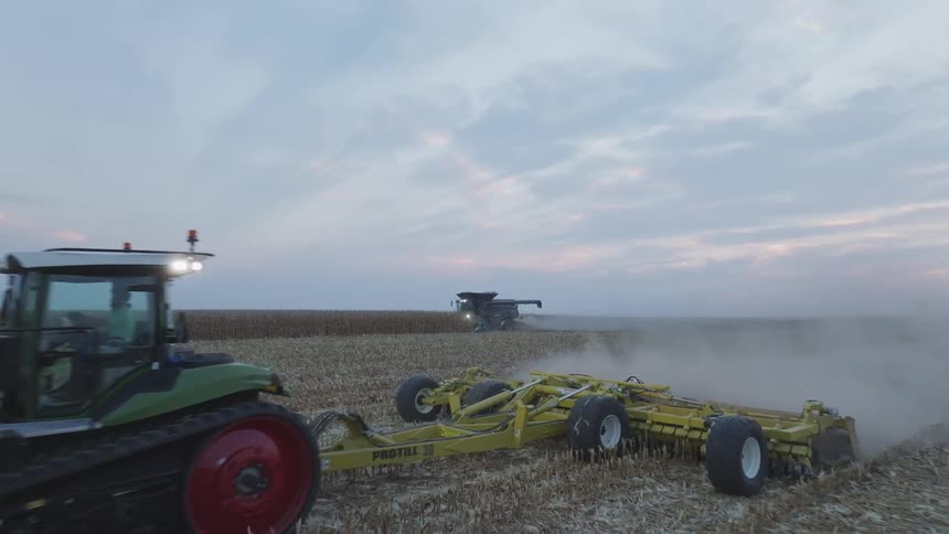 The farm vehicles are collecting crops on the farm