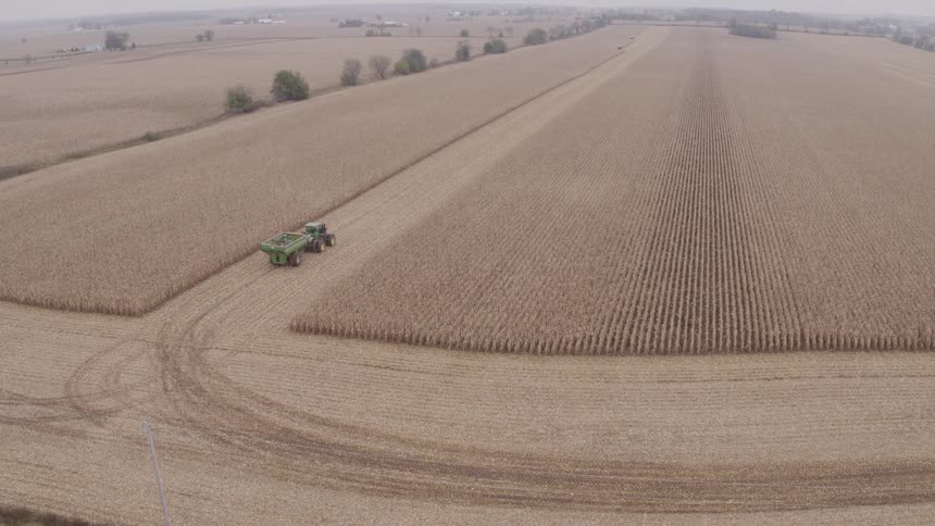Tractor with a trailer moving through a harvested field