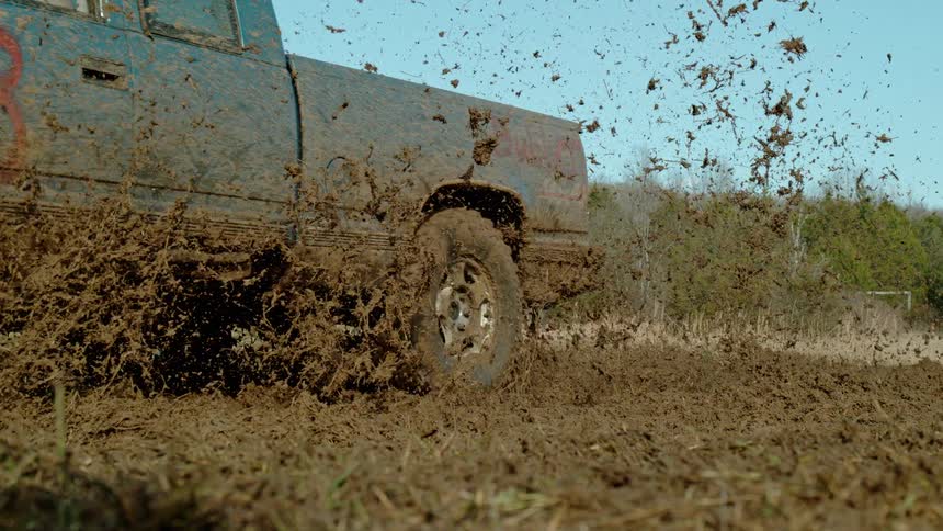 Mudcovered pickup truck accelerating on an offroad terrain