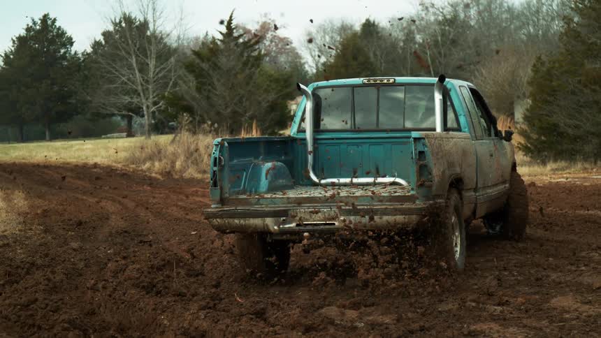 Mudcovered pickup truck speeding on an offroad terrain