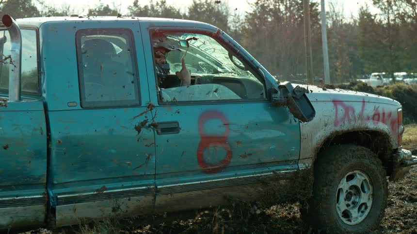 The truck drives through the mud splashing it all over