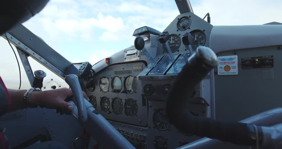 Control panel of an old aircraft with the pilot holding the yoke