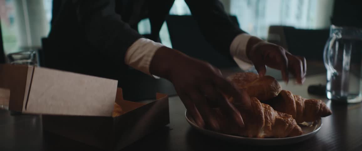 Woman arranges food on the table and takes one and puts it in her mouth