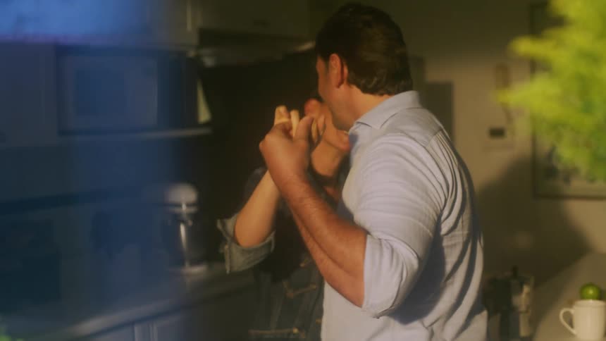 A couple dancing together while standing in a kitchen during daytime