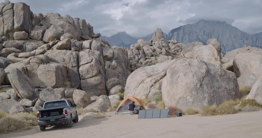 Man setting up his tent while camping in the canyon