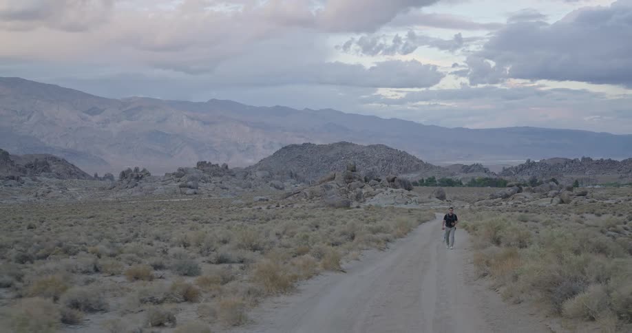 The man hikes down the long mountain trail