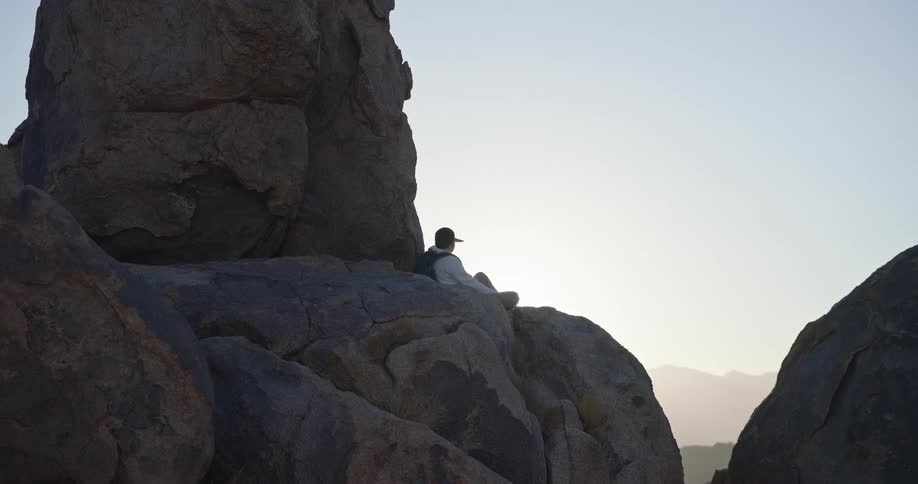 The man sits on the mountain top