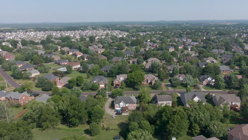 Singlefamily houses distributed along treelined streets in suburban neighborhood with abundant vegetation