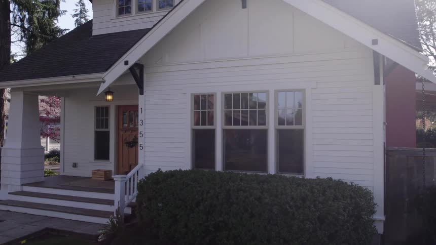 White house with gabled roof number 1355 and trimmed shrubs along the front