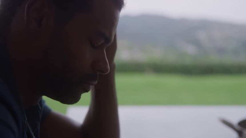 The man is sad while sitting outside