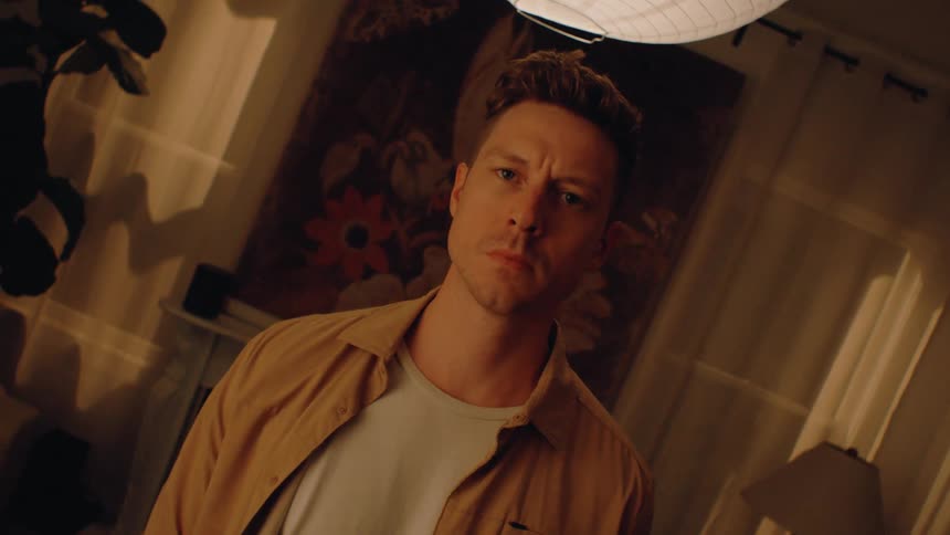 Close up portrait of a young man standing in a room at night