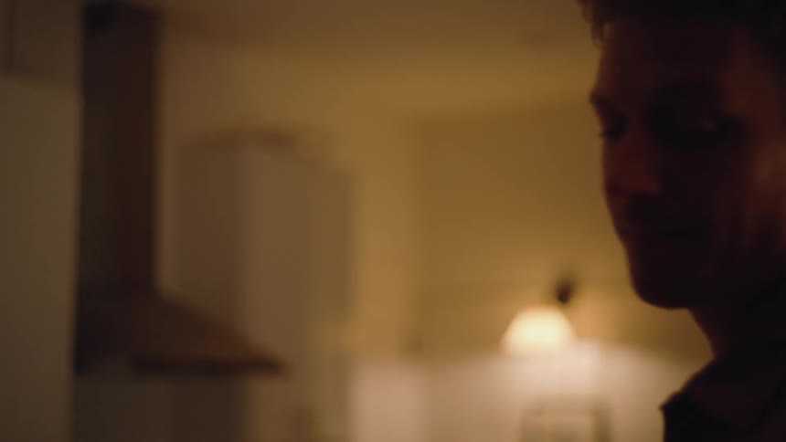 A young adult couple in an argument indoors with the female partner walking away shortly after