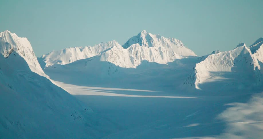Snowcovered mountain range under a clear blue sky