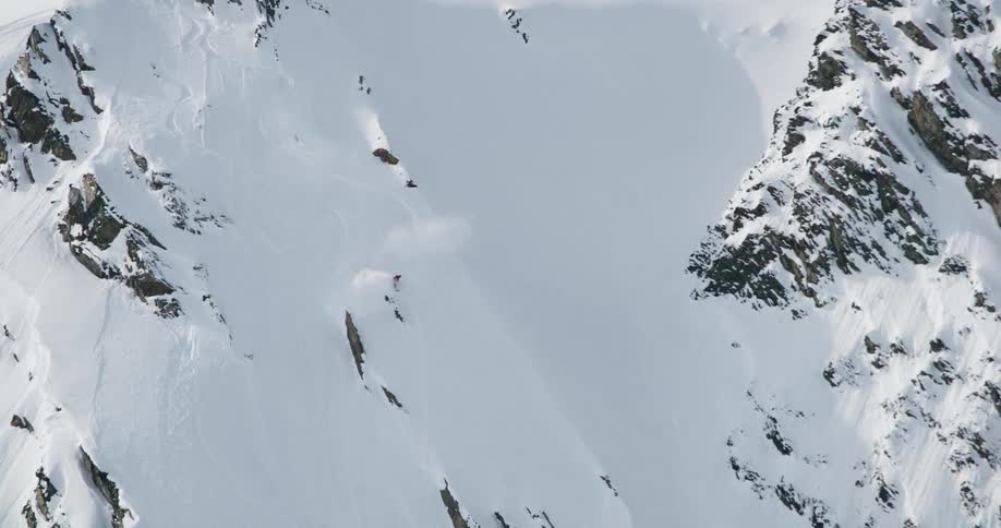 Skier descends a steep slope covered in fresh snow