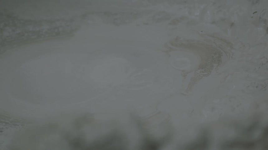 Thick gray mud bubbles slowly at the surface