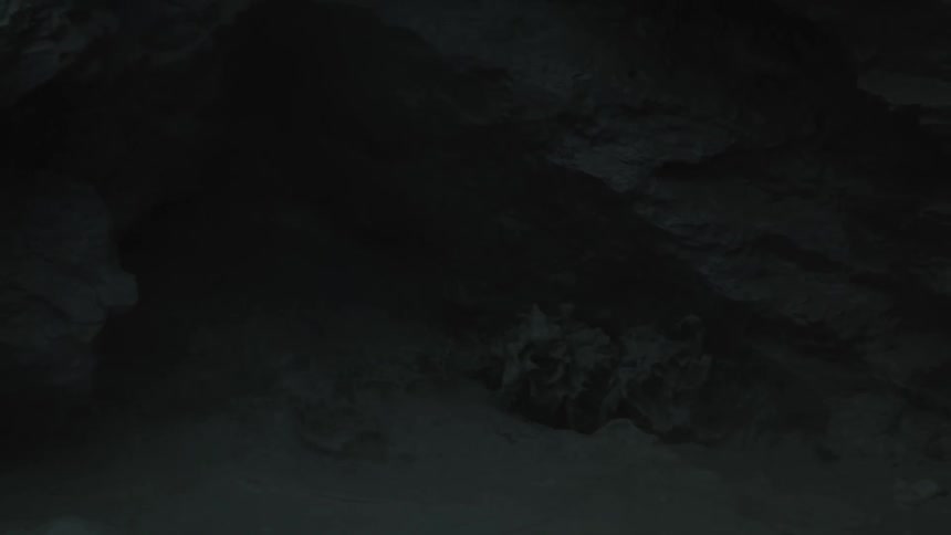 Black geothermal mud flows down a rocky surface