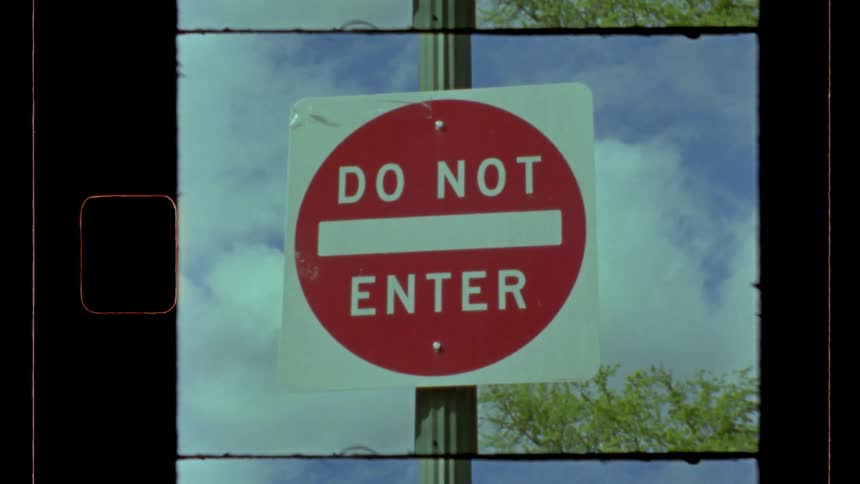 Do not enter sign is attached to a pole under a cloudy summer sky