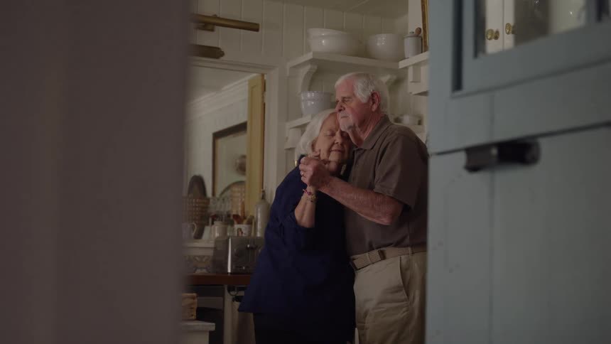 The couple are dancing together at home