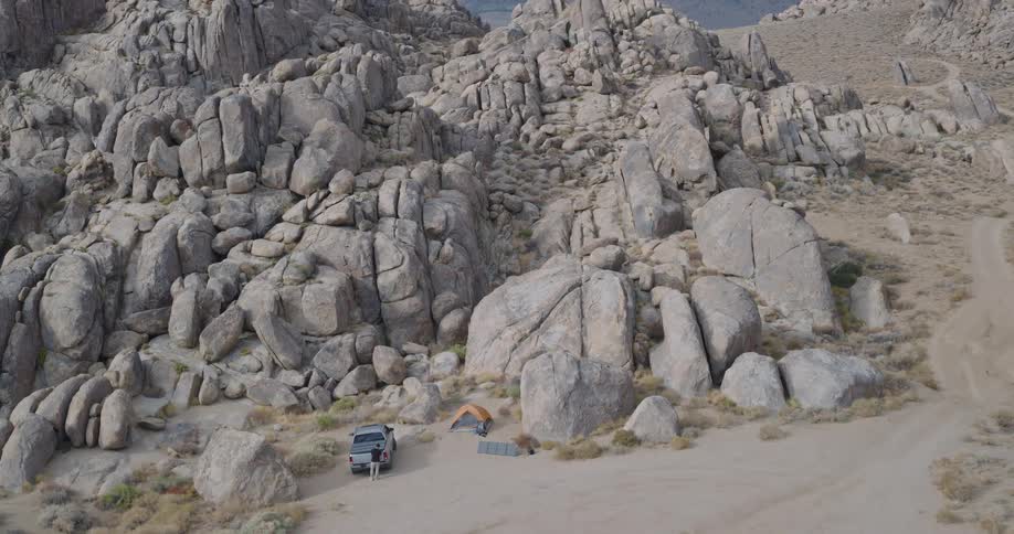 Man camps near tor formations in arid mountainous terrain