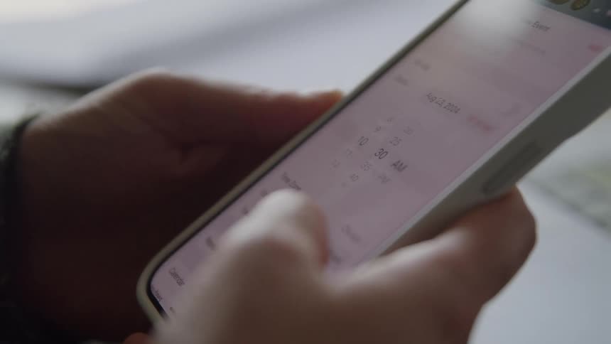 Closeup of a person holding and typing on a smartphone