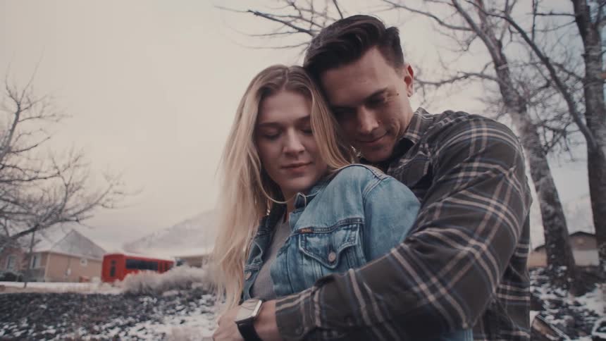 Couple in affectionate embrace outdoors during cold season