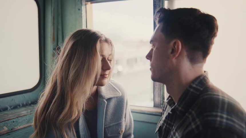 The man and woman kiss by the window