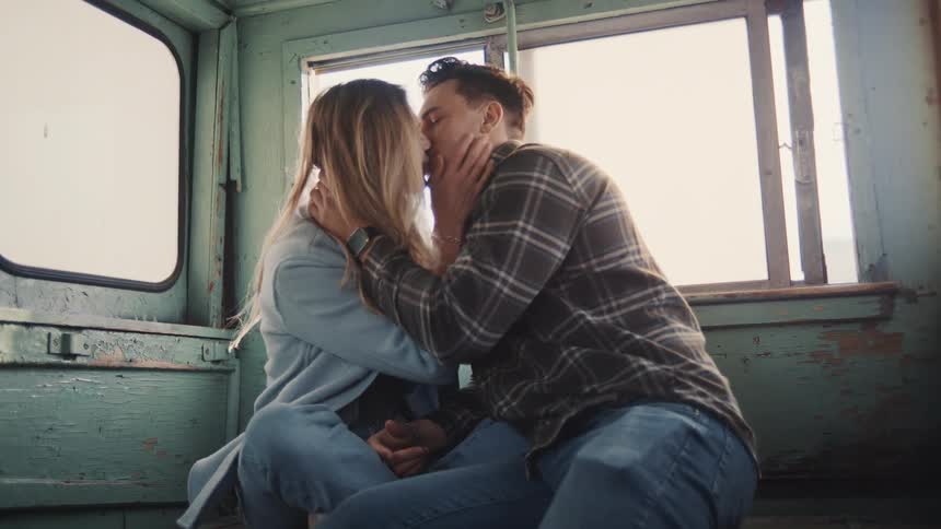 Couple sitting in rustic setting sharing intimate moment under natural light