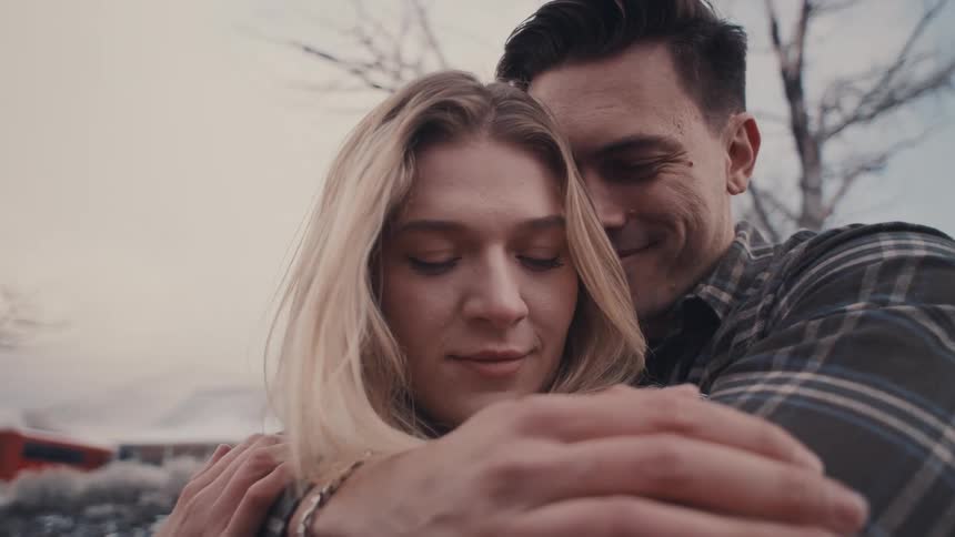 The man is hugging a woman from behind
