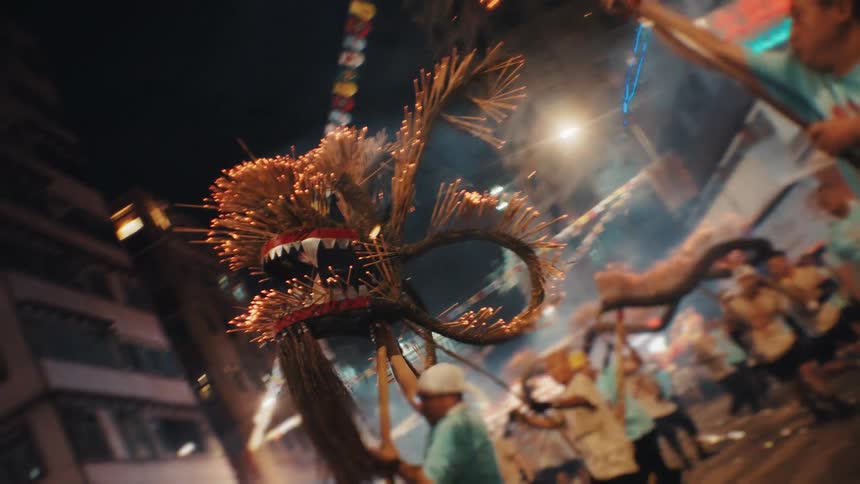Fire dragon is carried through the streets amid smoke and sparks