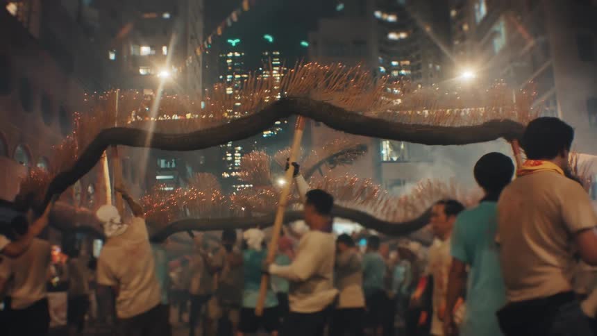 Participants carry a dragon made of burning incense sticks in a night parade