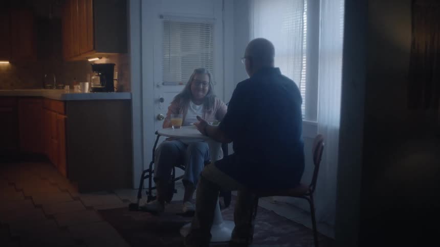 Couple praying while sitting at dining table in home