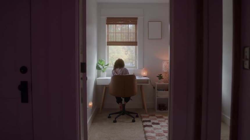Child sitting at a desk drawing in a room lit by natural light
